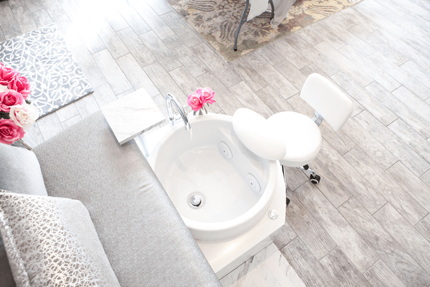 A white sink sitting next to a wooden floor.